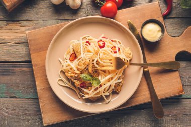 Ahşap arka planda lezzetli erişteli tabak.