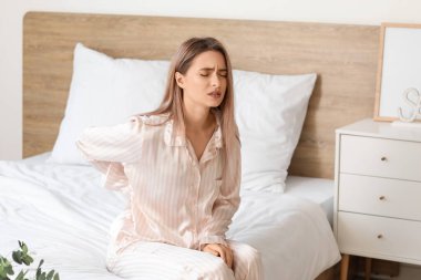 Genç bir kadın rahatsız edici bir yatak yüzünden sabahları sırt ağrısı çekiyor.