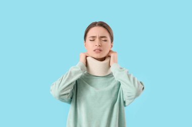 Boyununda boyun tasması olan genç bir kadın, arka planda acı çekiyor.