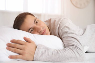 # Genç bir adamın yumuşak yatağıyla yattığı bir sabah #