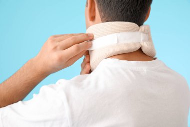 Boyunda boynu renkli tasması olan genç bir adam.