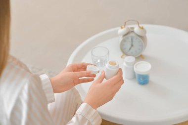 Evde hap alan güzel bir genç kadın.