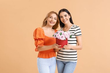 Renkli arka planda çiçekleri olan güzel kadınlar. Uluslararası Kadınlar Günü kutlamaları