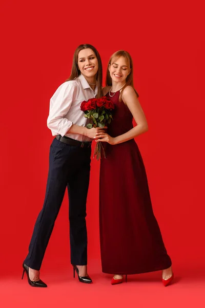 若いトランスジェンダーのカップルは背景色に花を咲かせます バレンタインデーのお祝い — ストック写真