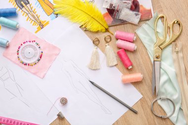 Ahşap arka planda çizimleri olan moda tasarımcısı işyeri