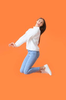 Renkli arka planda zıplayan genç kadın