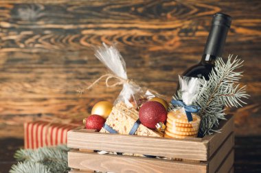 Ürünleri olan hediye sepeti ve ahşap arka planda Noel dekoru.
