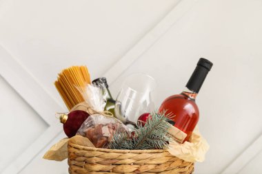 Ürünleri olan bir hediye sepeti ve ışık arka planında Noel dekoru