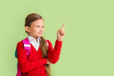 Küçük liseli kız renkli bir şeyler gösteriyor.