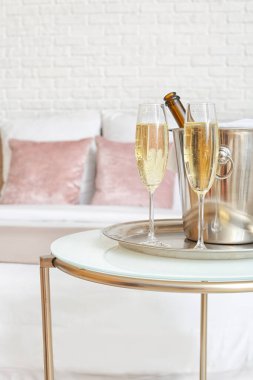 Otel balayı odasındaki masada bir şişe şampanya.