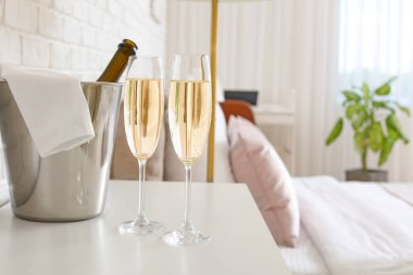 Otel balayı odasındaki masada bir şişe şampanya.