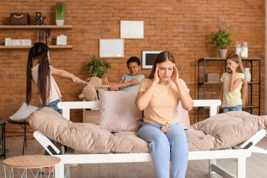 Çaresiz dadı ve odada oynayan yaramaz çocuklar.