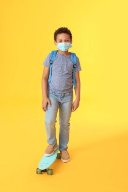Maskeli, kaykaylı ve renkli bir geçmişi olan küçük Afro-Amerikan öğrenci. Coronavirüs salgını