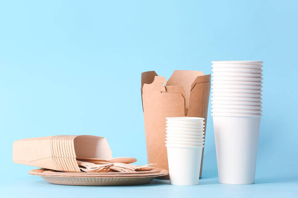 Экологическая посуда и контейнеры на цветном фоне