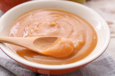 Ahşap arka planda elma reçeli ile kase ve kaşık