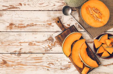 Ahşap zemin üzerinde tatlı kesilmiş karpuz ve tabak.