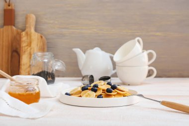 Masada taze yaban mersinli, muzlu ve ballı bir tabak lezzetli krep.