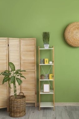 Renkli duvarın yanında katlanan ekran ve raf ünitesi