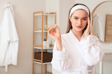 Süngerli güzel bir kadın evde makyaj yapıyor.