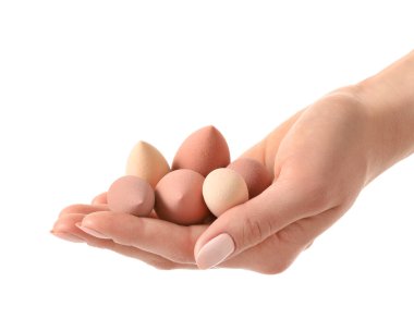 Beyaz arkaplanda makyaj süngeri olan el