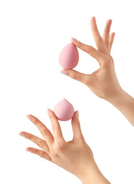 Beyaz arkaplanda makyaj süngeri olan eller