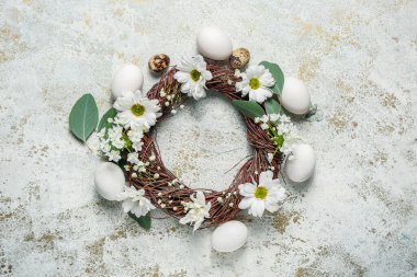 Hafif arka planda Paskalya yumurtaları ve bahar çiçekleriyle kompozisyon