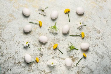 Hafif arka planda Paskalya yumurtaları ve bahar çiçekleriyle kompozisyon