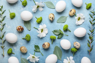 Renkli arka planda Paskalya yumurtaları ve bahar çiçekleriyle kompozisyon