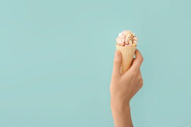 Elinde patlamış mısır toplu waffle külahı tutan kadın.