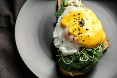 Tabağında floransa yumurtası olan lezzetli bir sandviç.