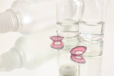 Işık arkaplanında çözeltisi olan kontak lensler ve şişeler