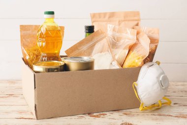 Ahşap zemin üzerinde farklı ürünler ve solunum cihazları olan bir kutu