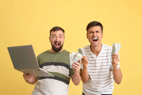 Happy men after winning of their sports bet on color background