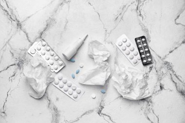 Damlalar, haplar ve kullanılmış mendillerle dolu bir şişe.