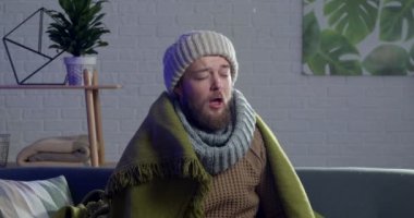 Evde hapşıran hasta adam.