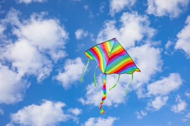 Mavi gökyüzünde uçan renkli uçurtma