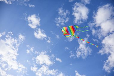 Mavi gökyüzünde uçan renkli uçurtma