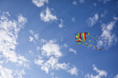 Mavi gökyüzünde uçan renkli uçurtma