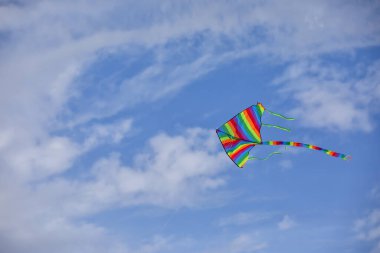 Mavi gökyüzünde uçan renkli uçurtma