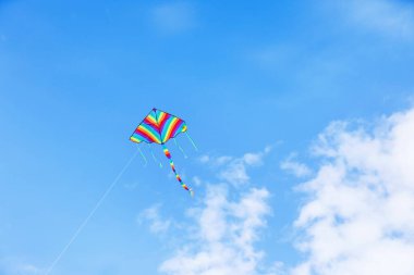 Mavi gökyüzünde uçan renkli uçurtma