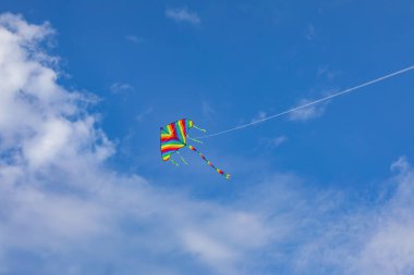 Mavi gökyüzünde uçan renkli uçurtma