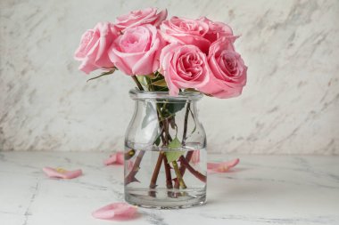 Açık arkaplanda vazoda güzel pembe güller