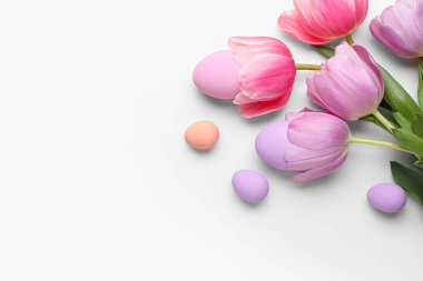 Beyaz arka planda yumurta ve bahar çiçekleriyle güzel bir Paskalya kompozisyonu