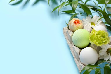 Renkli arkaplanda yumurta ve bahar çiçekleri olan güzel Paskalya kompozisyonu