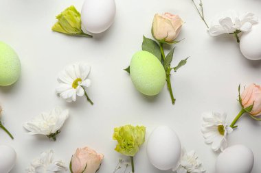Beyaz arka planda yumurta ve bahar çiçekleriyle güzel bir Paskalya kompozisyonu