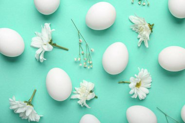 Renkli arkaplanda yumurta ve bahar çiçekleri olan güzel Paskalya kompozisyonu