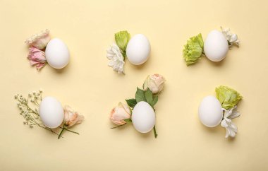 Renkli arkaplanda yumurta ve bahar çiçekleri olan güzel Paskalya kompozisyonu