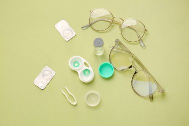 Renk arkaplanında kontak lens ve aksesuarlarla kompozisyon