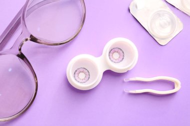 Renk arkaplanında kontak lens ve aksesuarlarla kompozisyon