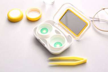 Gözlük, cımbız ve kontak lensli konteynır.